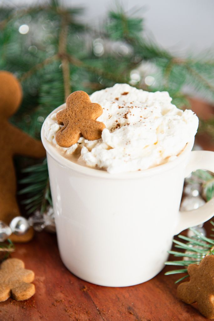 a close up of a finished gingerbread latte with a mini gingerbread cookies on top