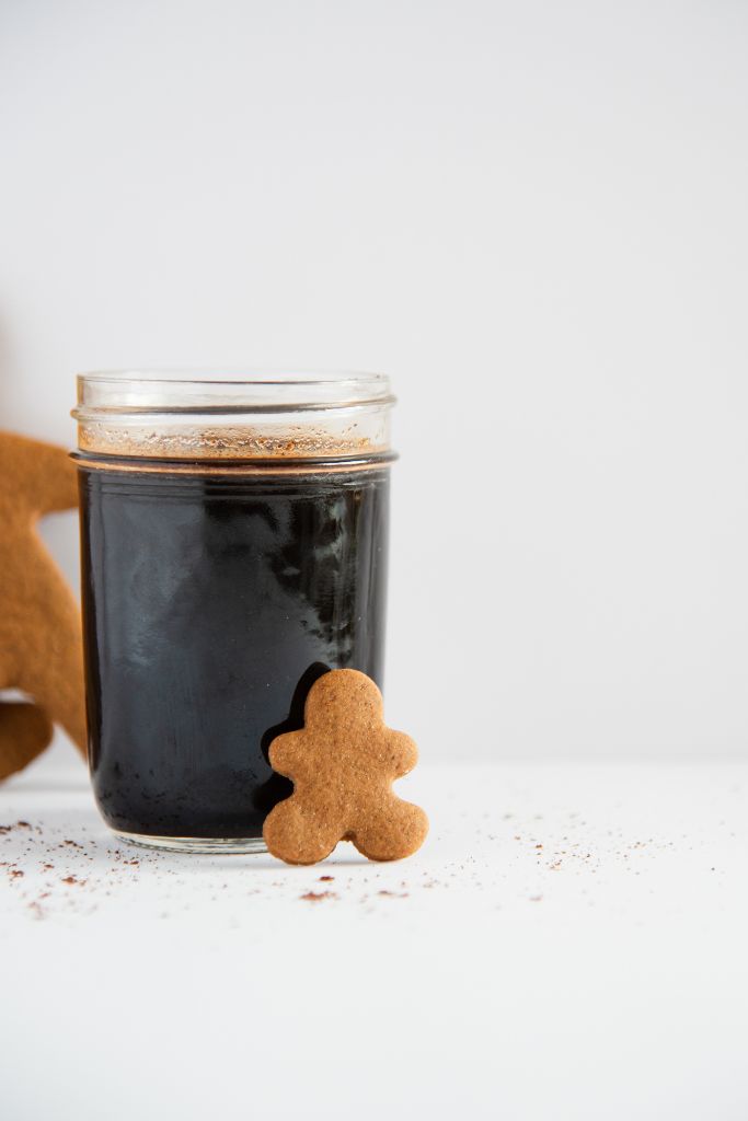 a close-up of a jar of gingerbread syrup with a gingerbread man lining against 