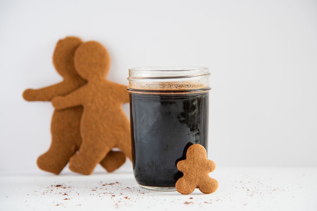 a jar of gingerbread syrup with a gingerbread man lining against it