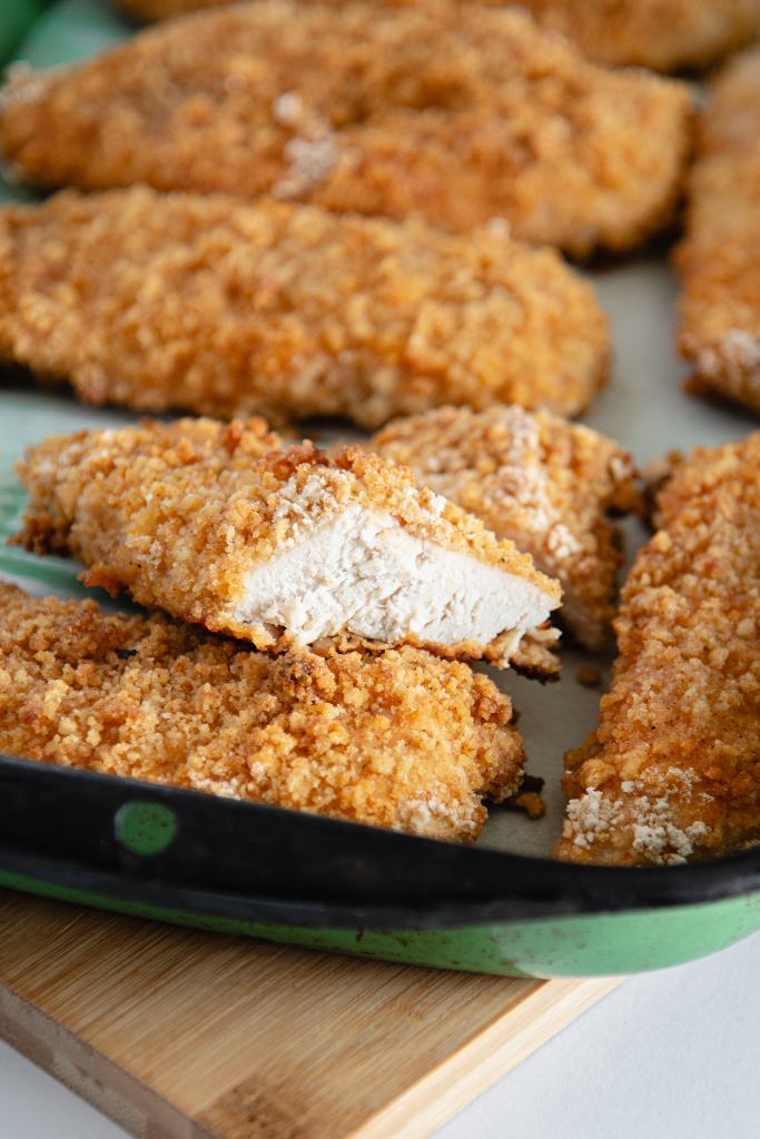 a cut piece of fried chicken propped up on another piece of chicken