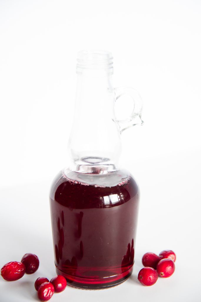 a glass bottle of cranberry simple syrup
