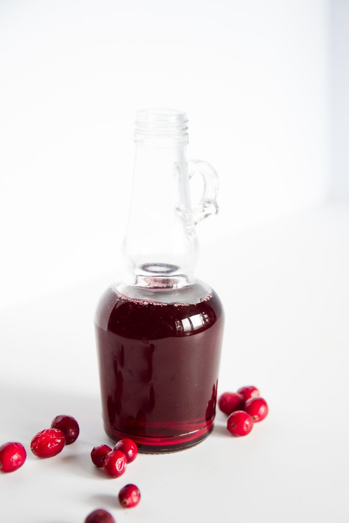 a glass bottle of cranberry simple syrup 