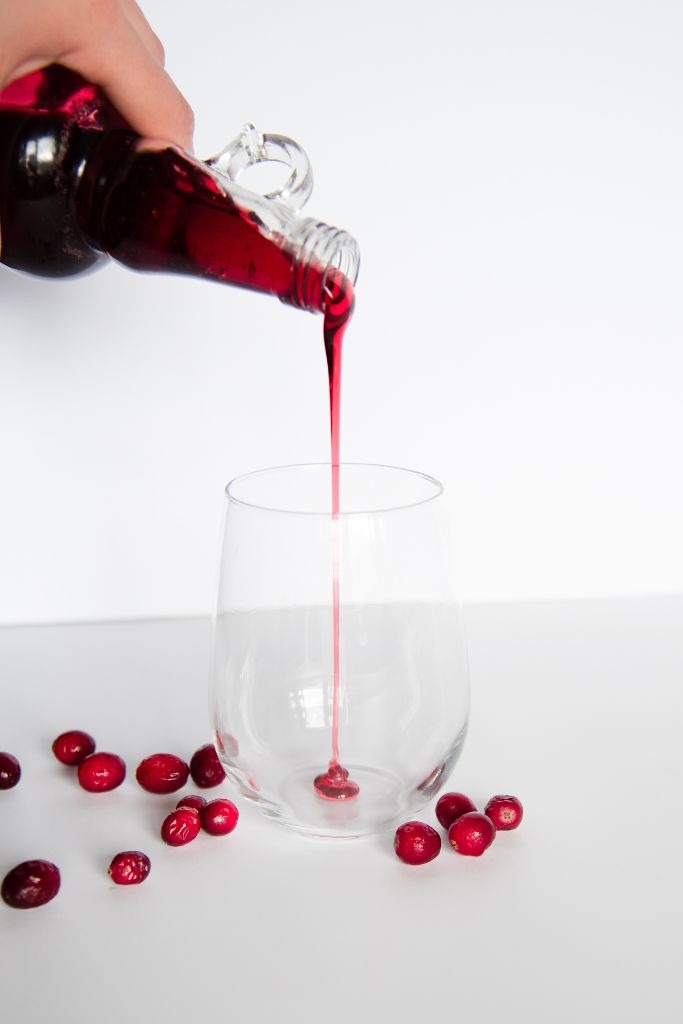 cranberry syrup being poured into a glass
