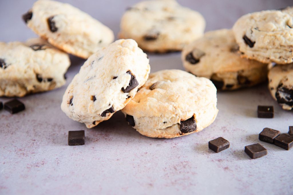 a bunch on biscuits stacked on top of each other with chocolate chunks around them