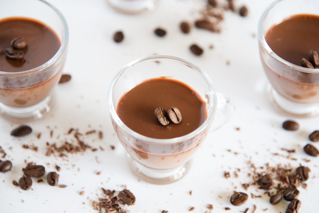 a finished shot with coffee beans and chocolate around it 