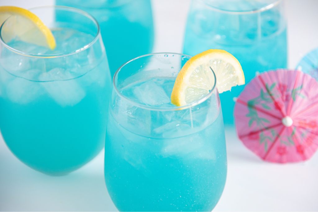 a glass of spiked lemonade with a lemonade slice next to it 