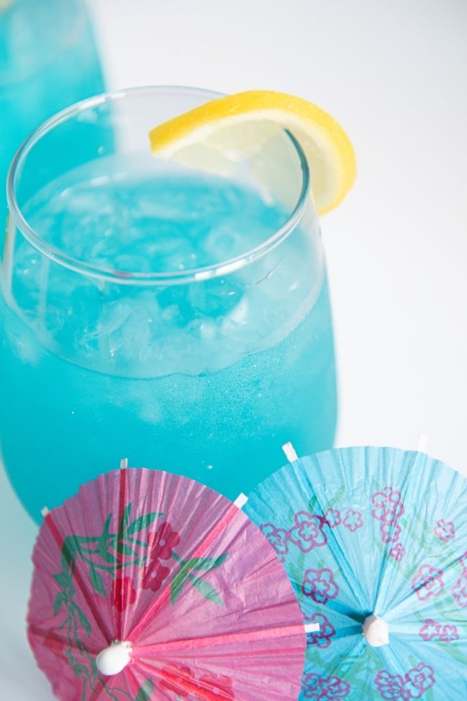 a glass of lemonade with two drink umbrellas 