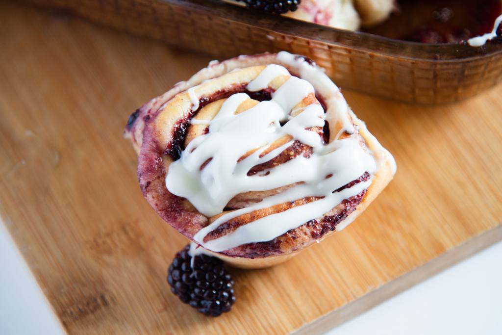 a blackberry sweet roll on a wooden dish