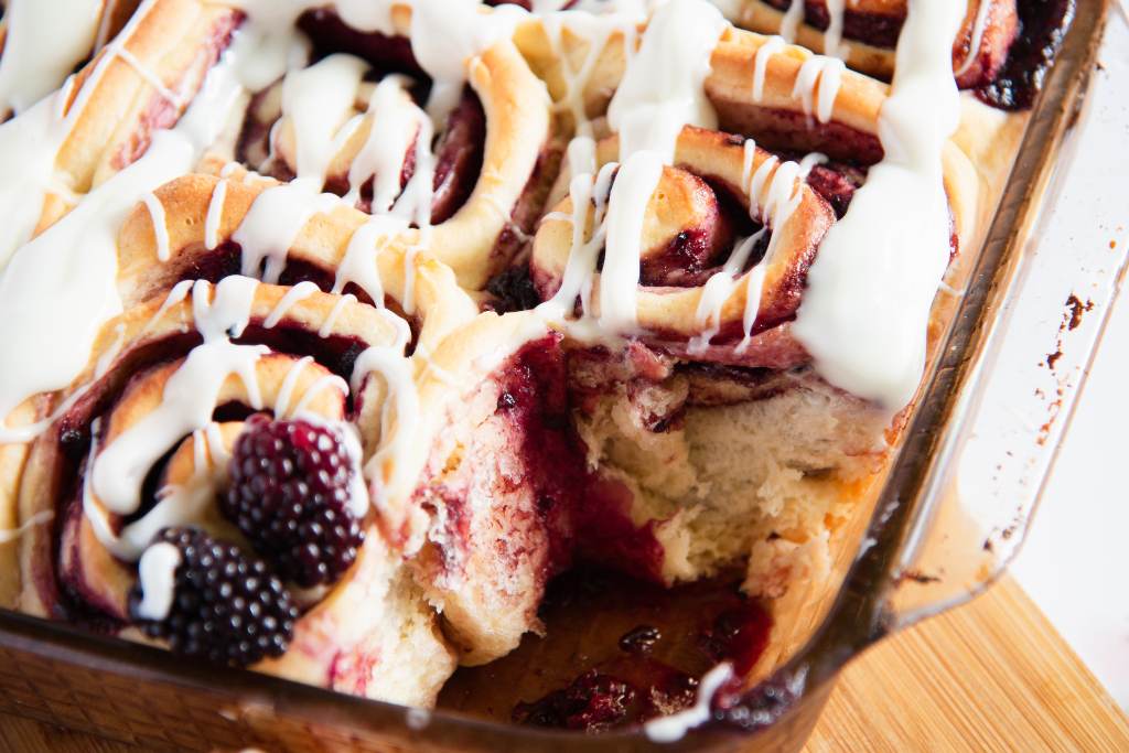 a pan sweet rolls that has one taken out of it 