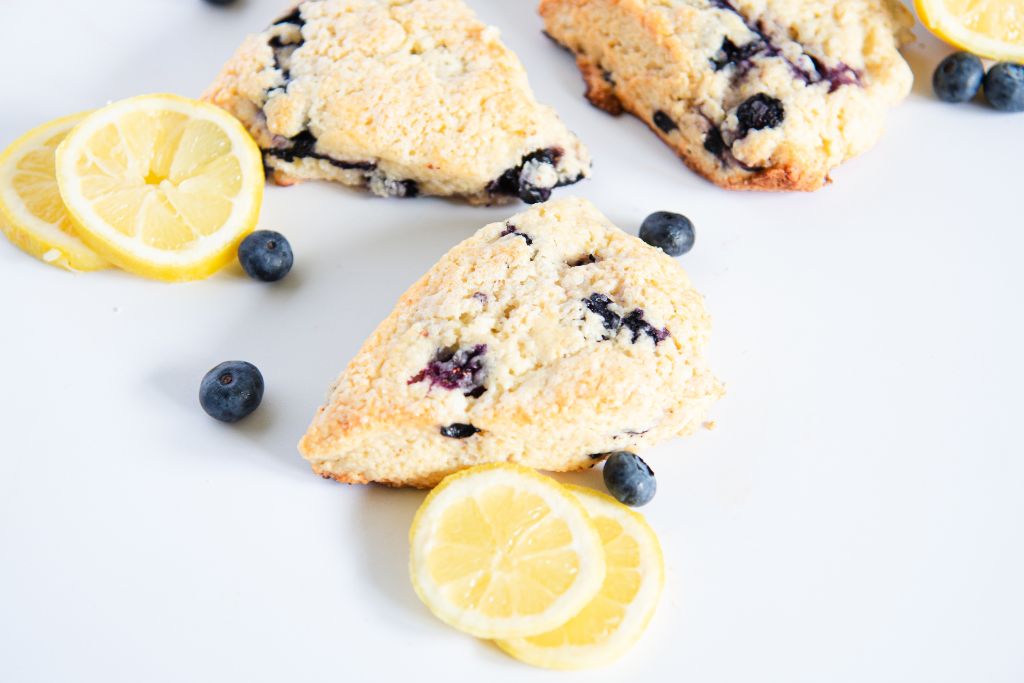 blueberry lemon scones with lemon slices and fresh bluebrries around them