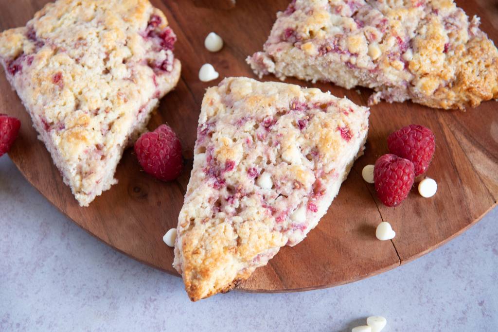 white chocolate raspberry scones on a wooden plate