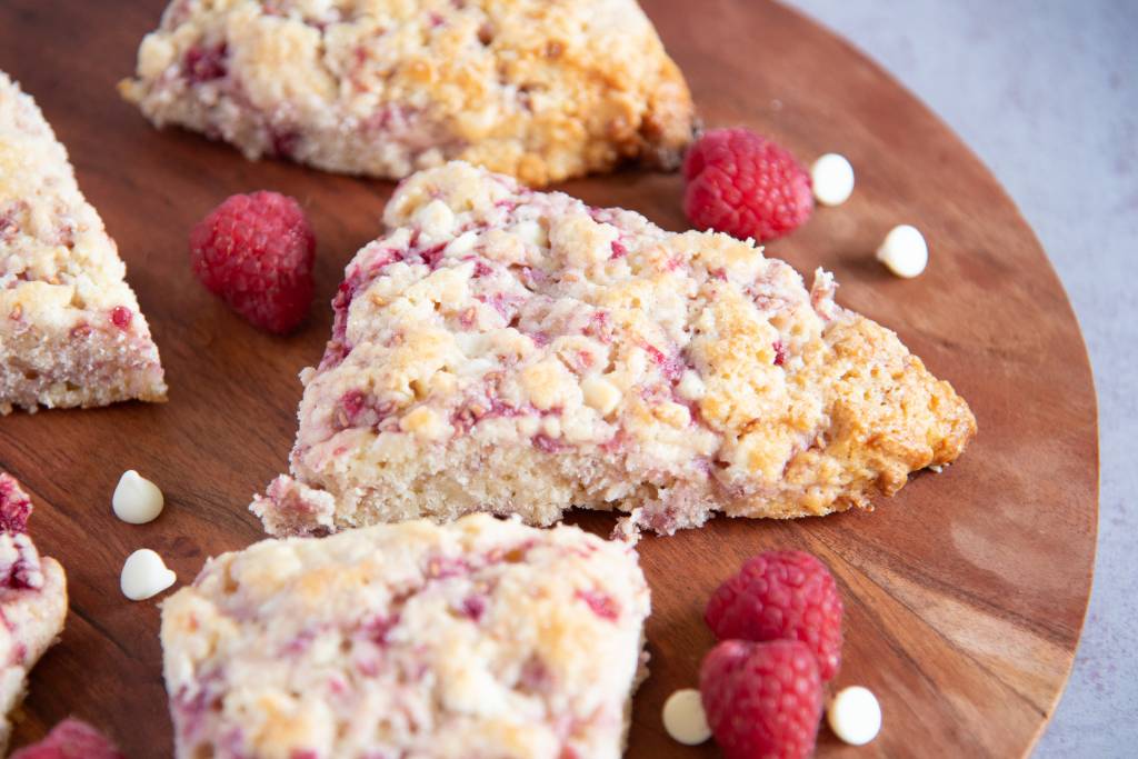 a close up of scones on a wooden plate