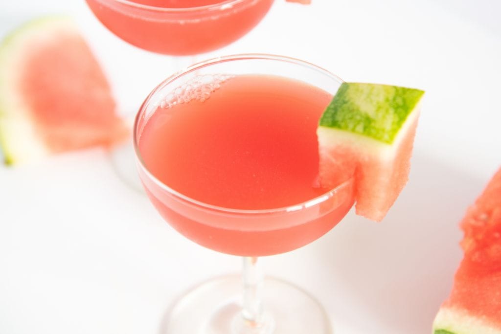 a close up of a watermelon cocktail, you can see part of another cocktail behind it 