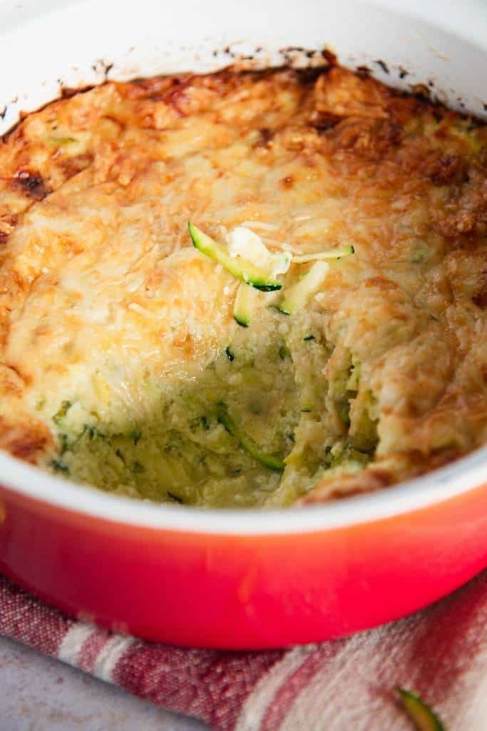 a dish of zucchini casserole with a spoonful taken out it