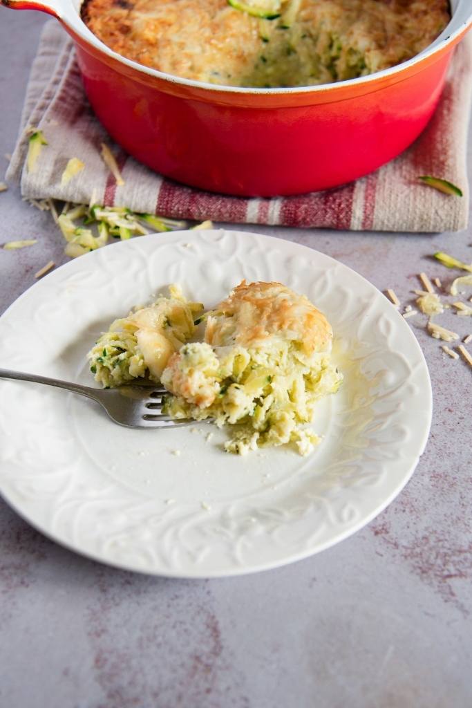 a plate with zucchini casserole and a fork on it