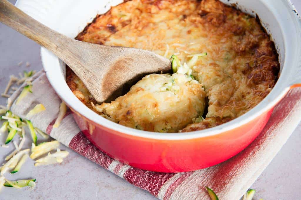 a dish of zucchini casserole with a spoon in it