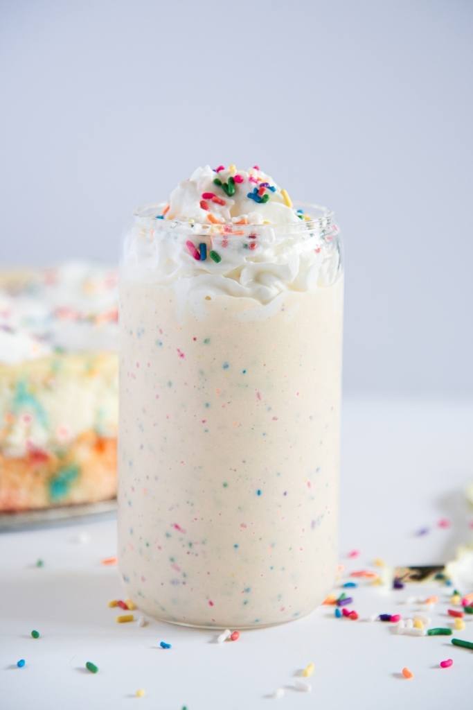 a birthday cake milkshake with sprinkles around it