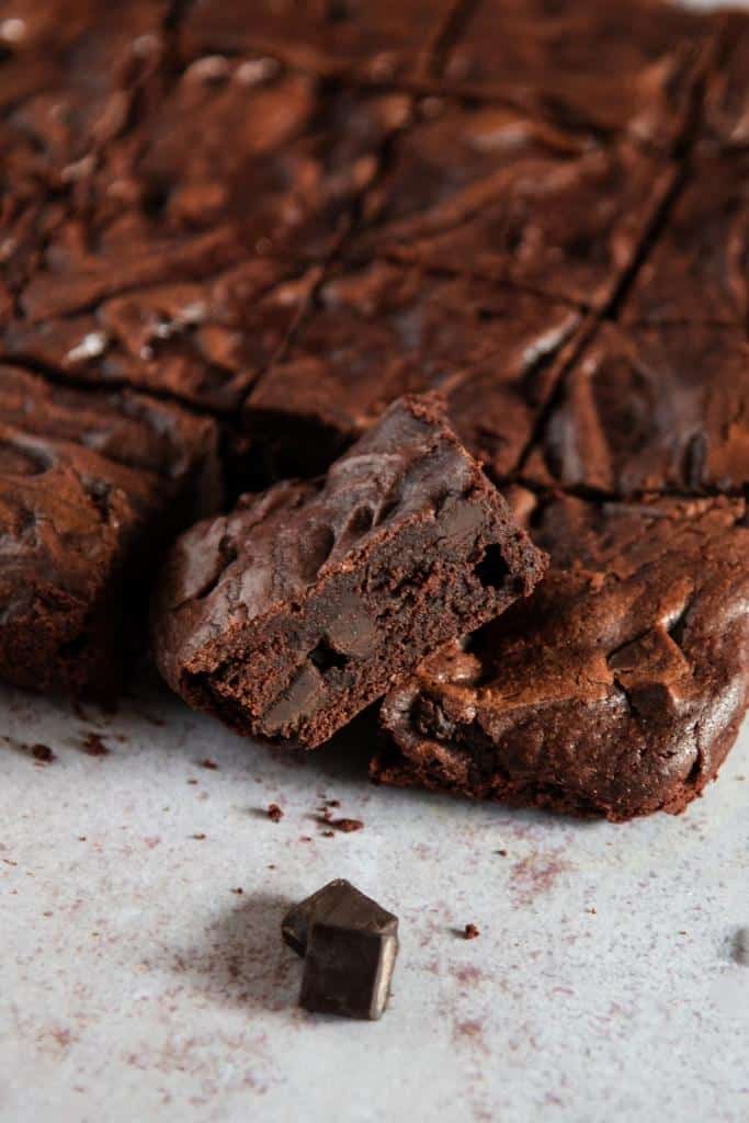 a brownie resting on a sheet of brownies 