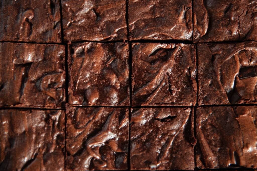 a close up of a cut sheet of brownies 