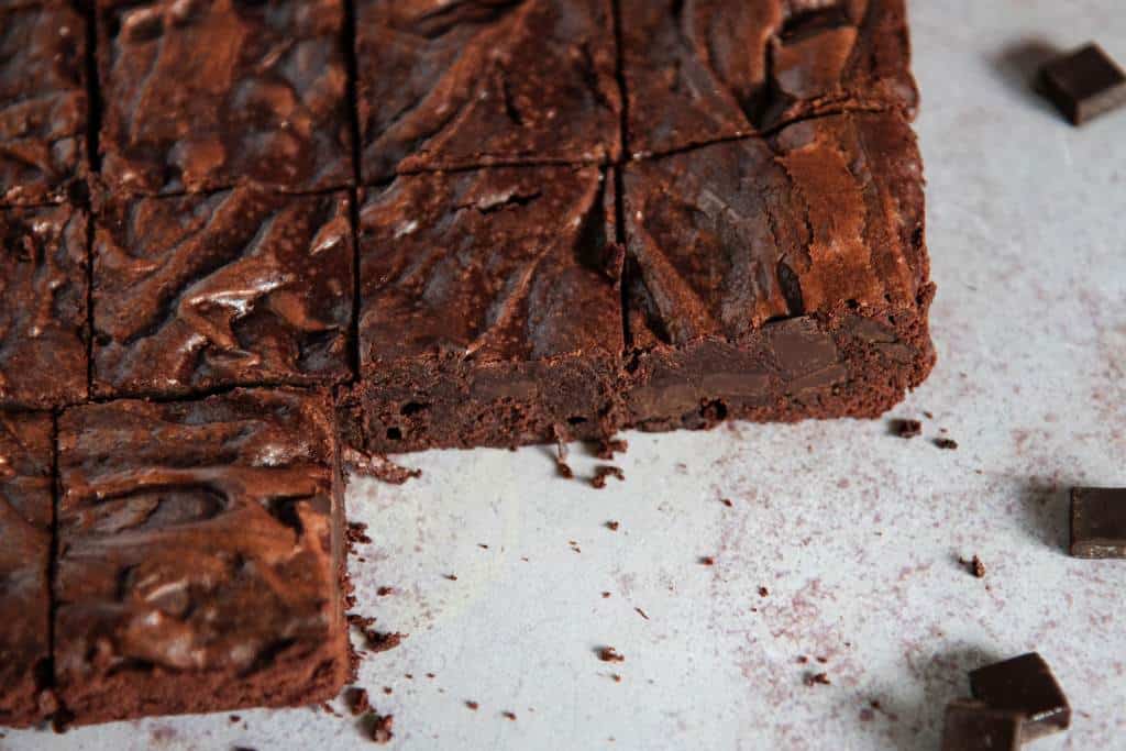 a cut sheet of brownies that has two  brownies taken out of it 