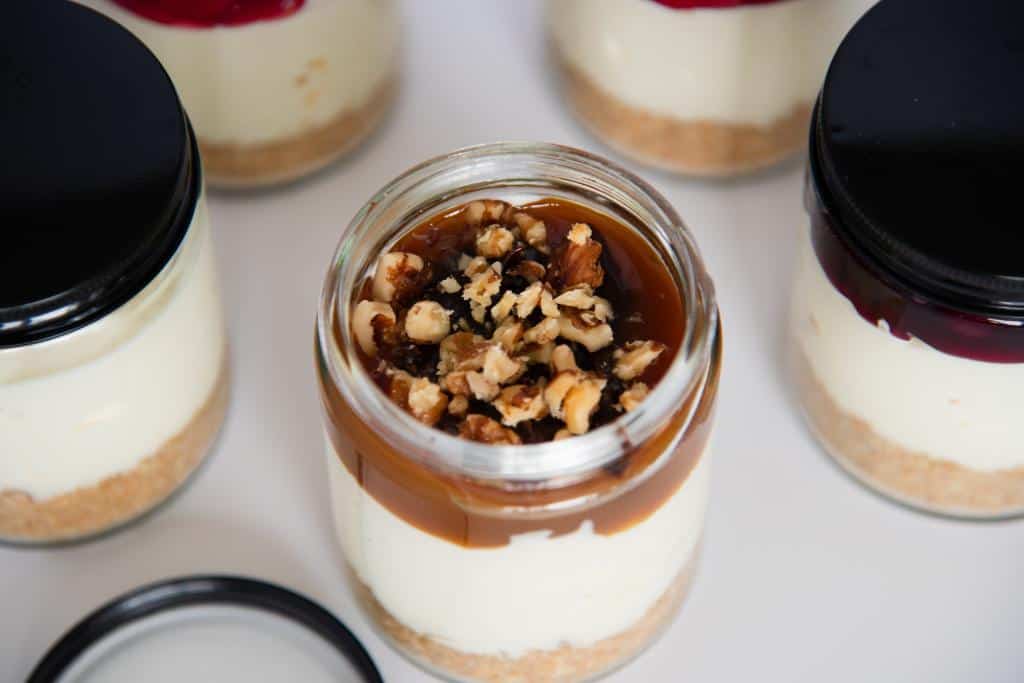 an overhead shot of jar of cheesecake with turtle topping