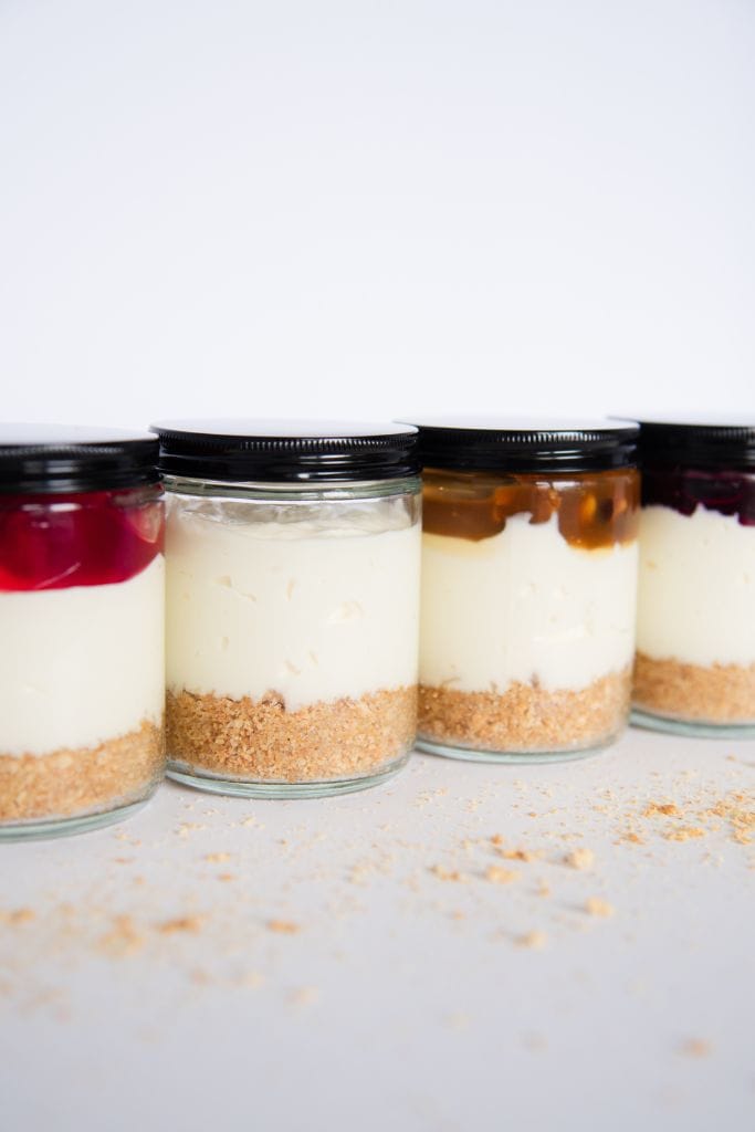 a four jars of no bake cheesecake with lids on