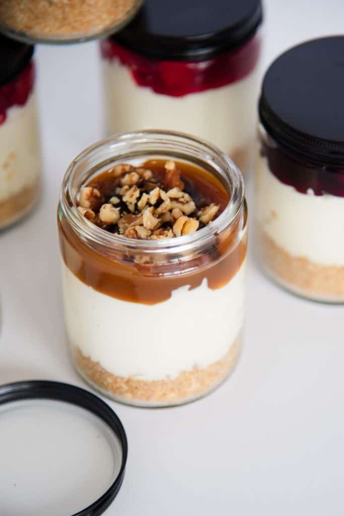 a close up of a jar of cheesecake with a turtle topping