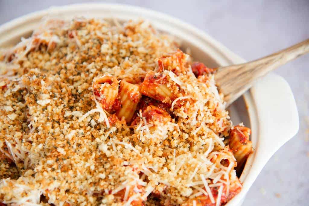 a dish of pasta with a wooden spoon in it 