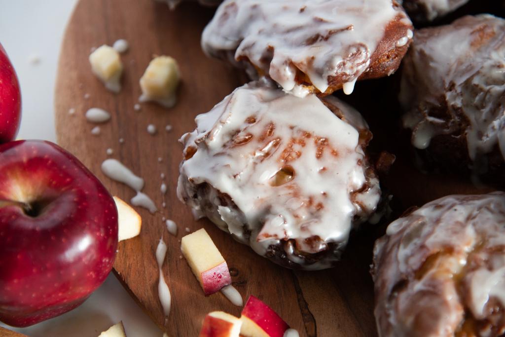 a close up of a plate of fritters with apples and apple pieces next to it 