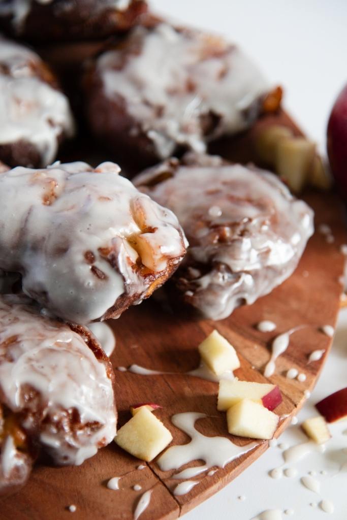 apple fritters on a plate with apple pieces next to them