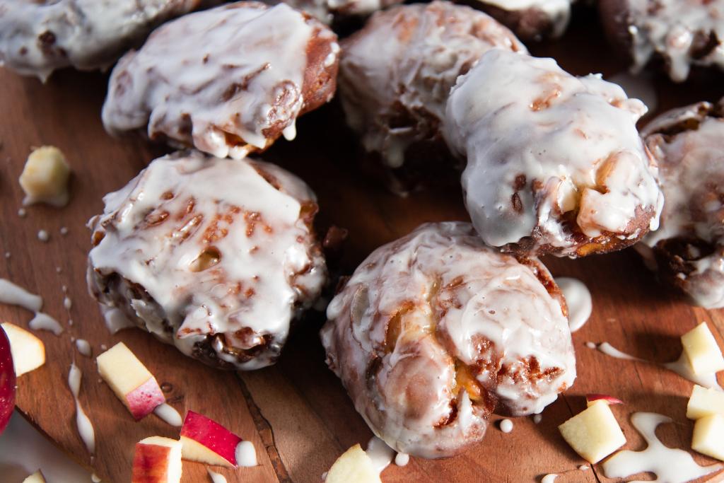 a plate of apple fritters with apple pieces next to them