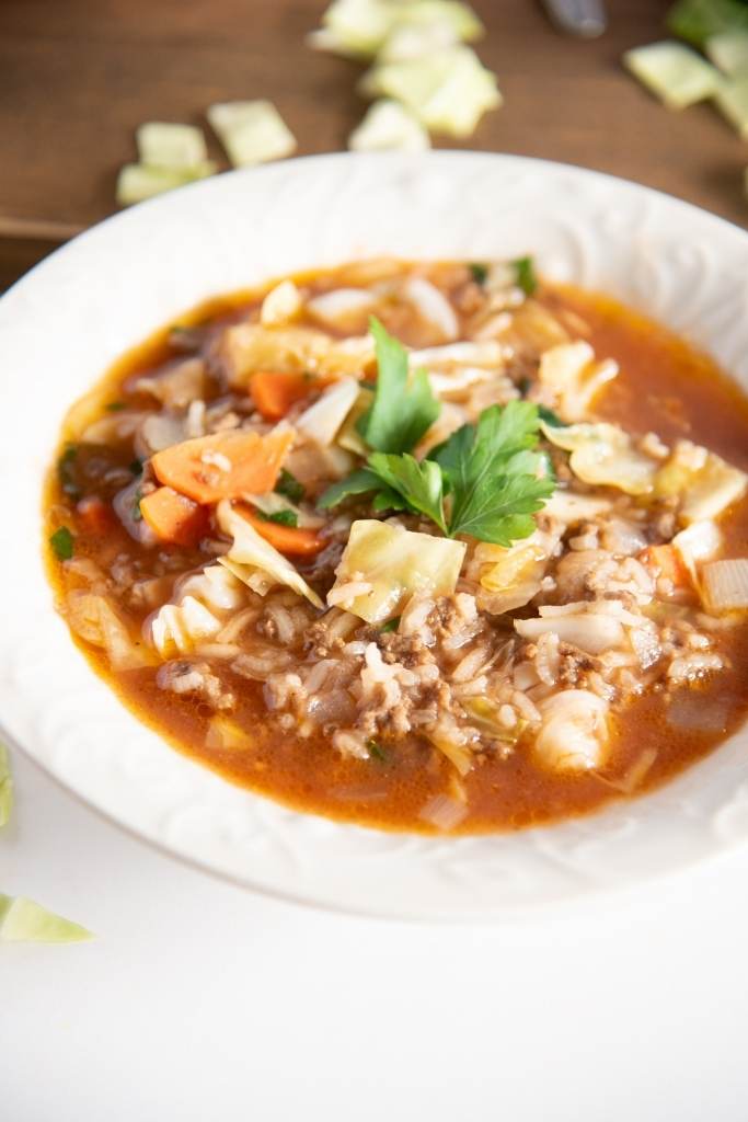 a close up of a bowl of soup with parsley on top 