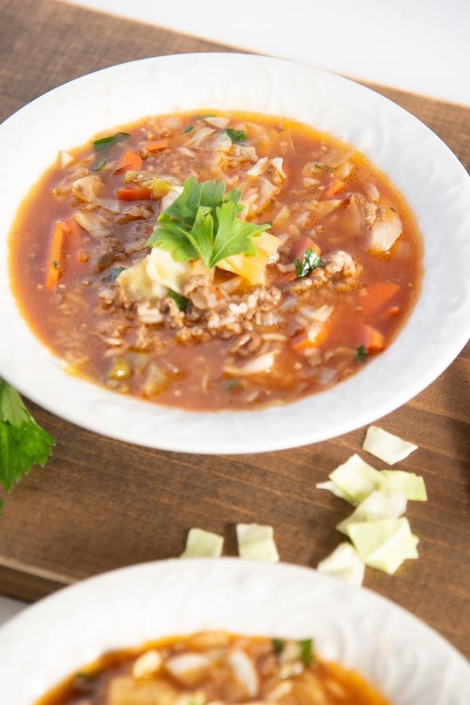 a bowl of soup, y can see part of another bowl in front of it 
