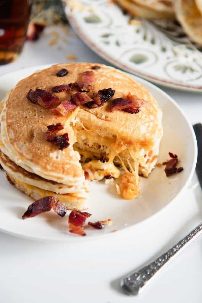 a plate of grilled cheese pancakes that has a bite cut out of it