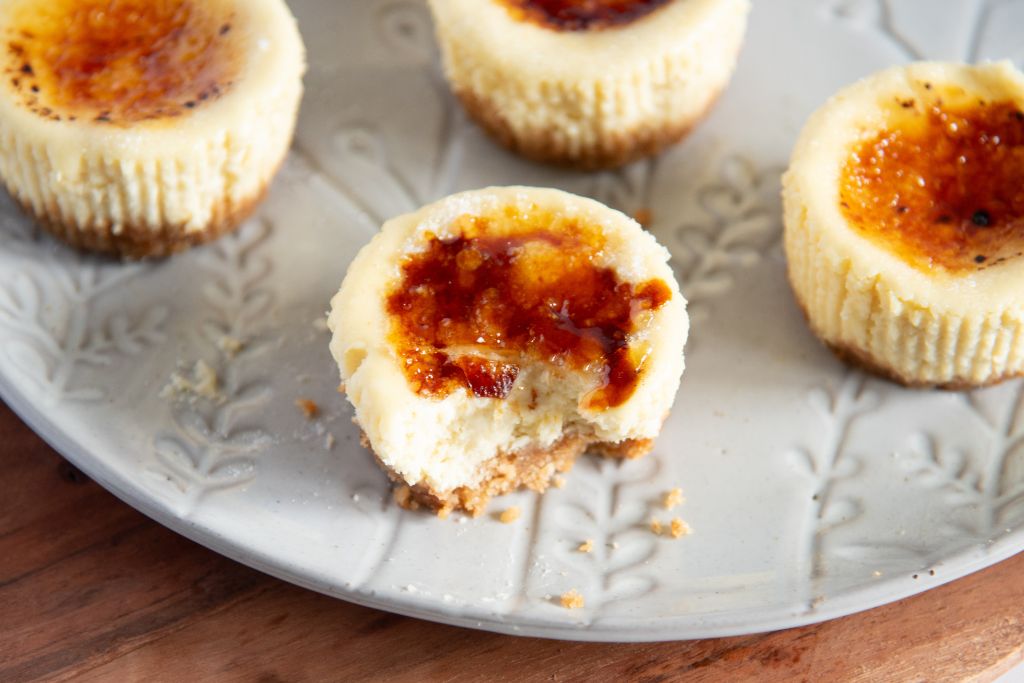 a close up of a mini cheesecake with a bit taken out of it