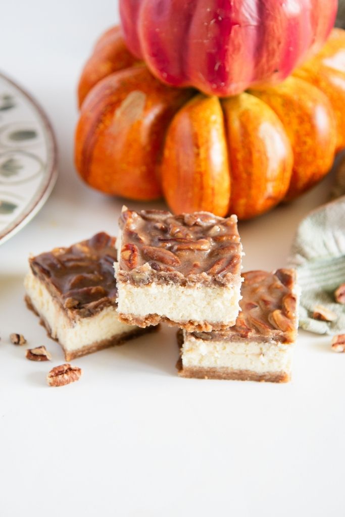 cheesecake bars stacked in from on a pumpkin decoration 