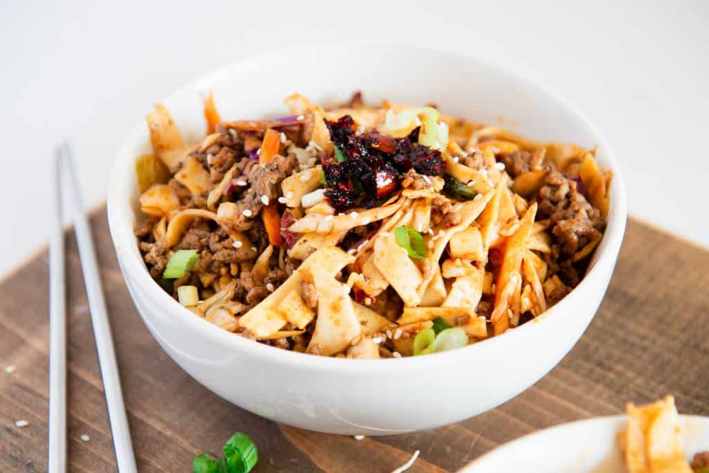 a bowl of noodles with chop sticks next to it