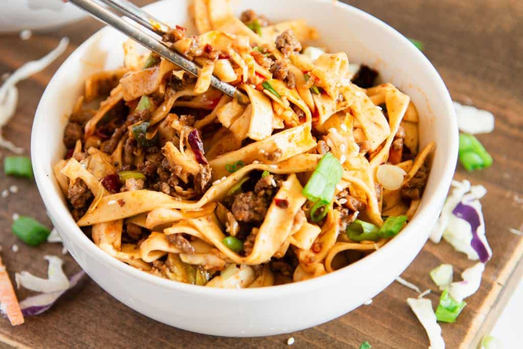 a close up of a bowl of spicy noodles