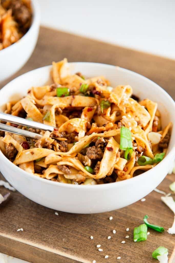 a bowl of noodles with chop sticks in it