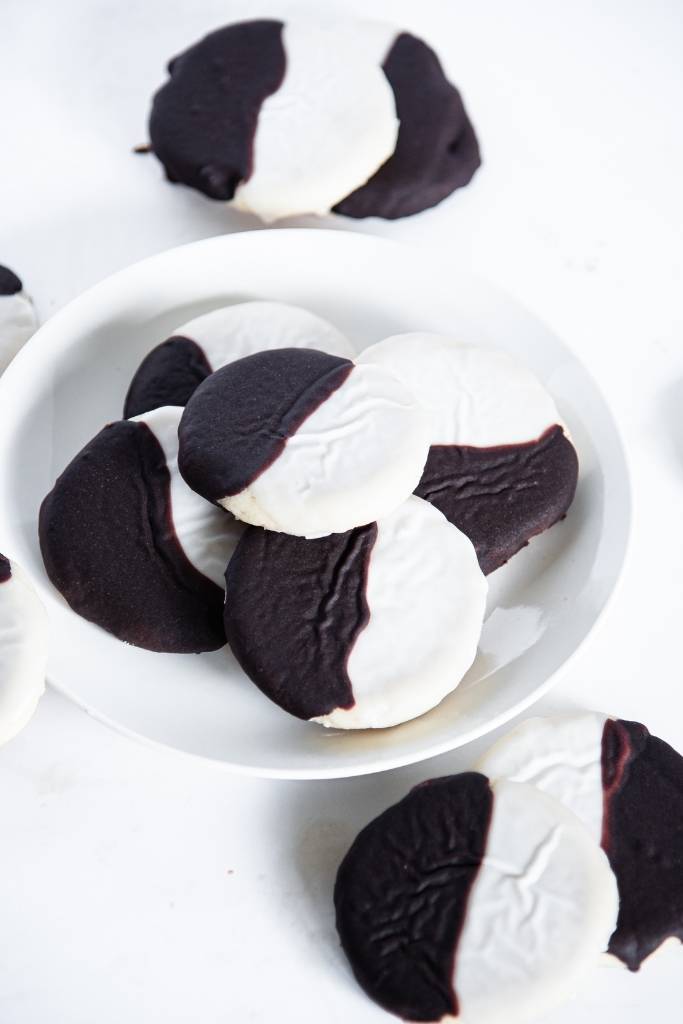 a plate of cookies, there are some cookies stacked next to the plate as well