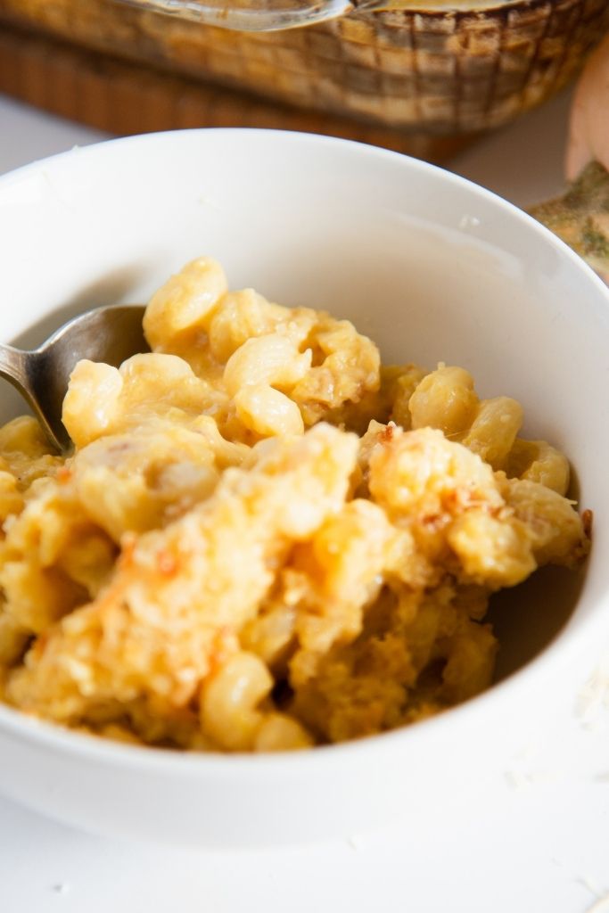 a close up of a spoon with a few noodles on it in a bowl of mac and cheese