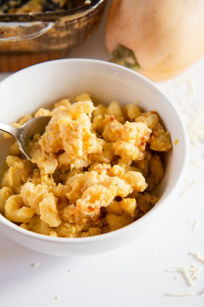 a spoonful of mac and cheese being taken out of a bowl of mac and cheese