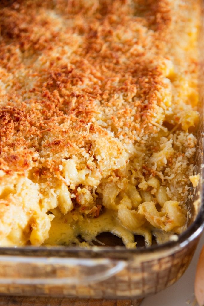 a close up of a pan of mac and cheese that has a spoonful taken out of it 