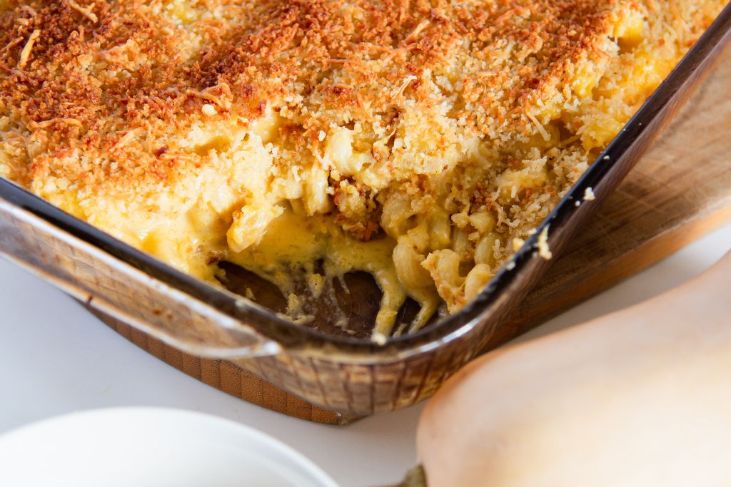 a pan of mac and cheese with a spoonful taken out of it 