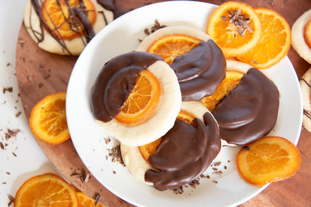 an overhead shot of a plate of shortbread cookies with candied orange slices around it 