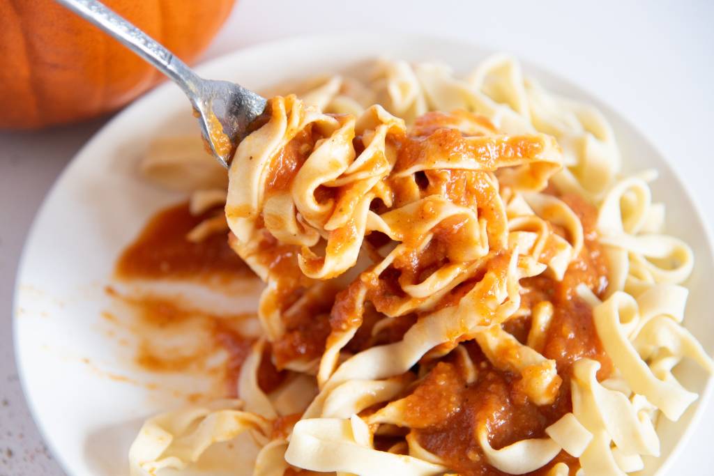 a forkful of noodles and pumpkin pasta sauce
