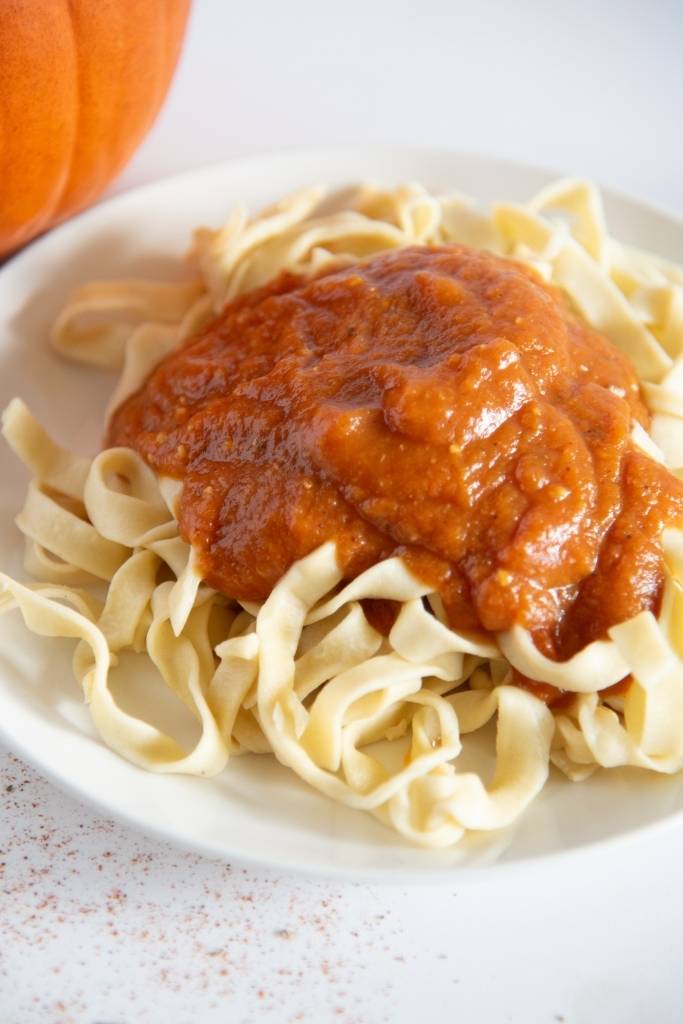 a close up of a plate of noodles with pumpkin pasta sauce
