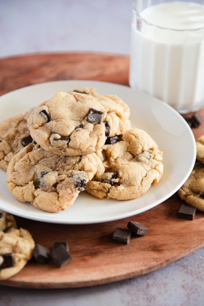 a plate of sourdough cookies with a glass of milk behind it 