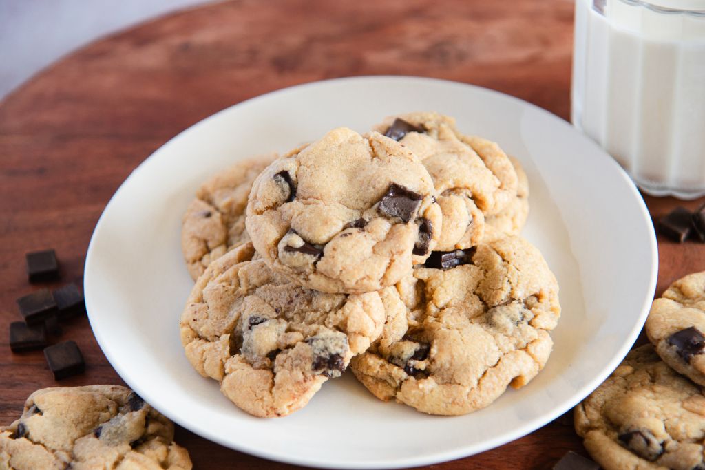 a plate of cookies with  glass of milk next to it 