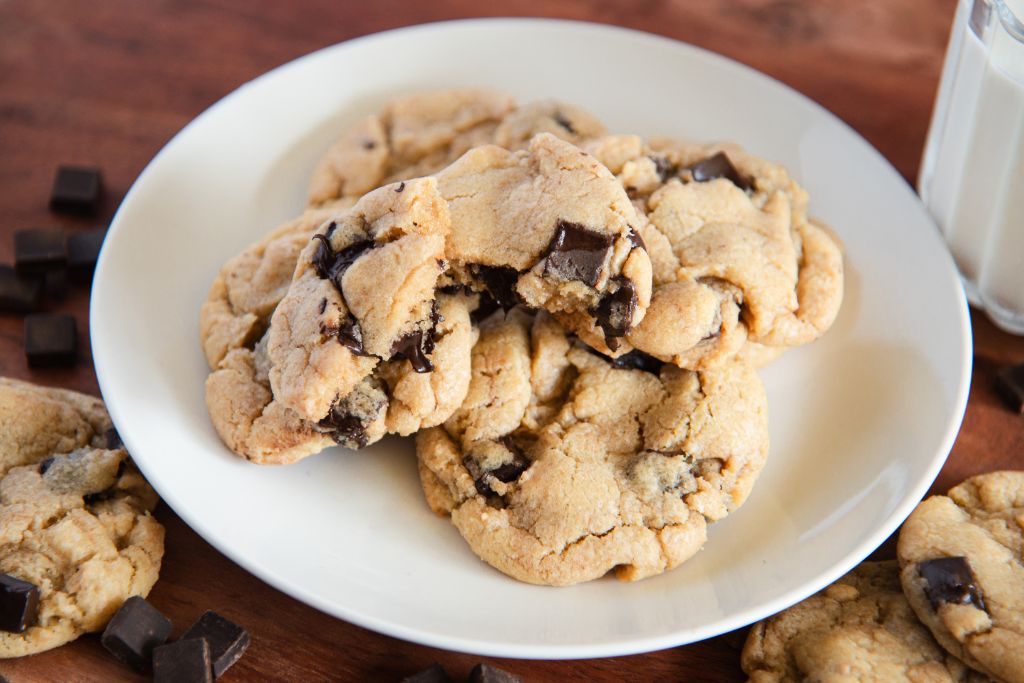 a clos up of a plate of sourdough cookies, the cookie in top has been broken off.